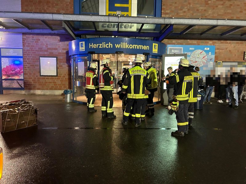 Vor dem Übungsobjekt stehen Einsatzkräfte und Mitarbeitende