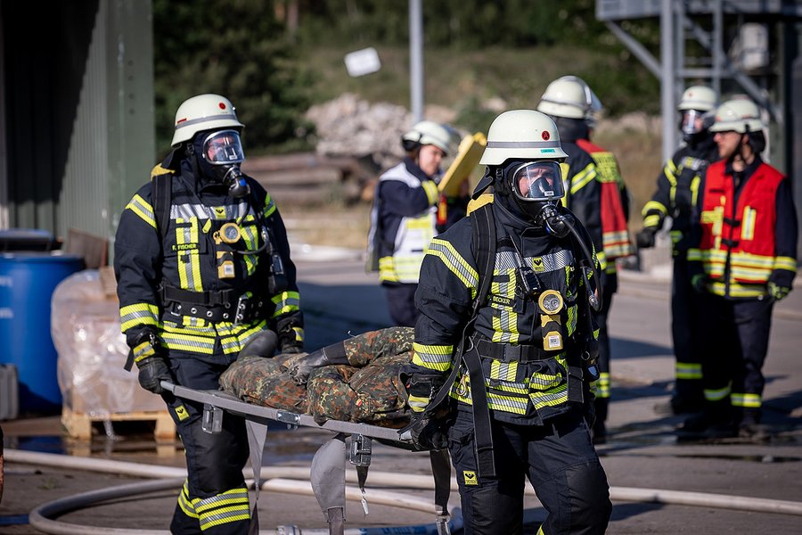 Trupp trägt verletzten Mitarbeiter zum Rettungsdienst